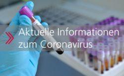 Eine behandschuhte Hand hält ein Probenröhrchen mit einer positiv auf das Coronavirus getesteten Blutprobe. Im Hintergrund sind weitere Probenröhrchen zu sehen. Ein Pfeil weist darauf hin, dass das Bild verlinkt ist.