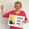 Die Ministerin hält ein Plakat in den Händen. Darauf steht: Equal pay day