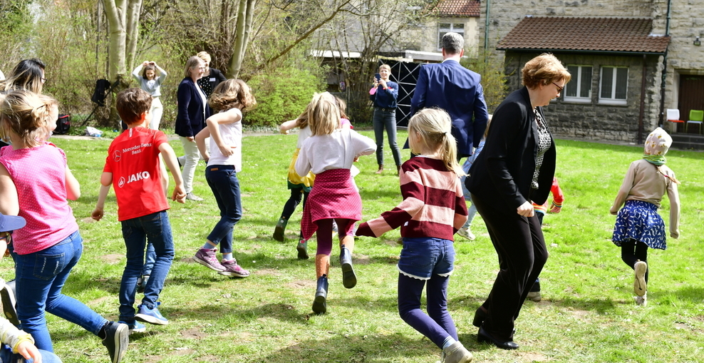 Kinder auf grüner Wiese mit Ministerin