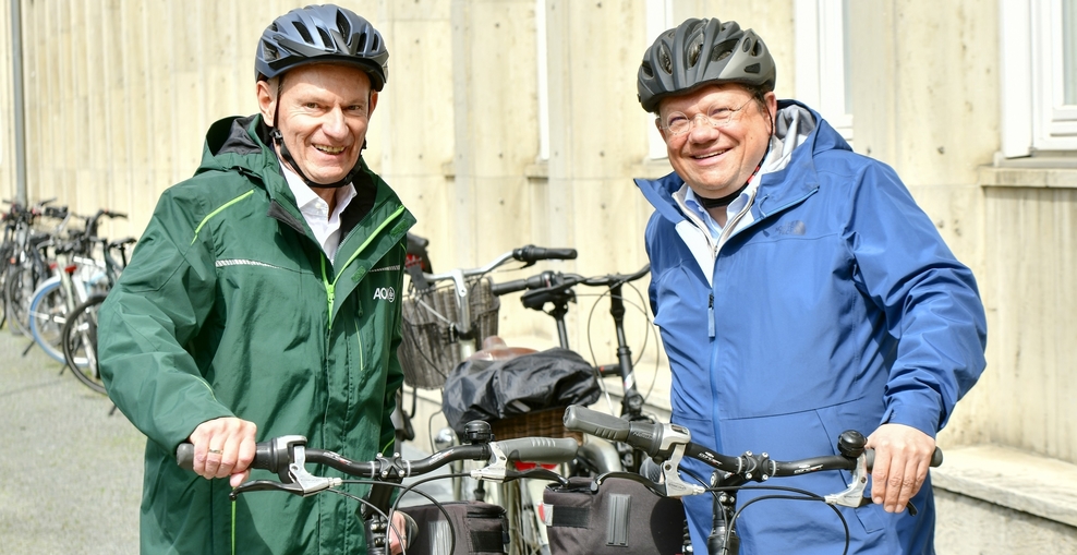 Dr. Peter und Dr. Philippi stehen neben ihren Fahrrädern