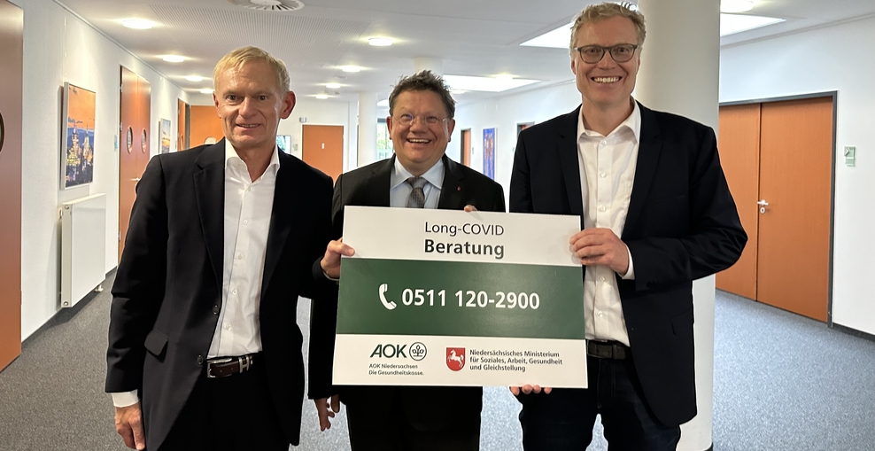 Dr. Peter, Dr. Philippi und Prof. Schneider mit Schild zur Long-Covid Beratung