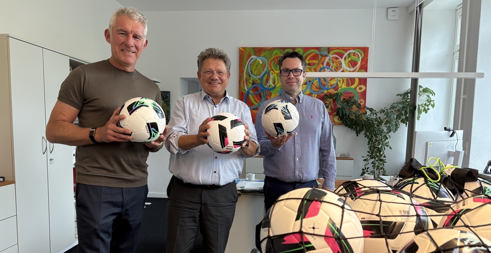 Mirko Slomka, Minister und Dr. Lekkos mit Fußbällen in der Hand